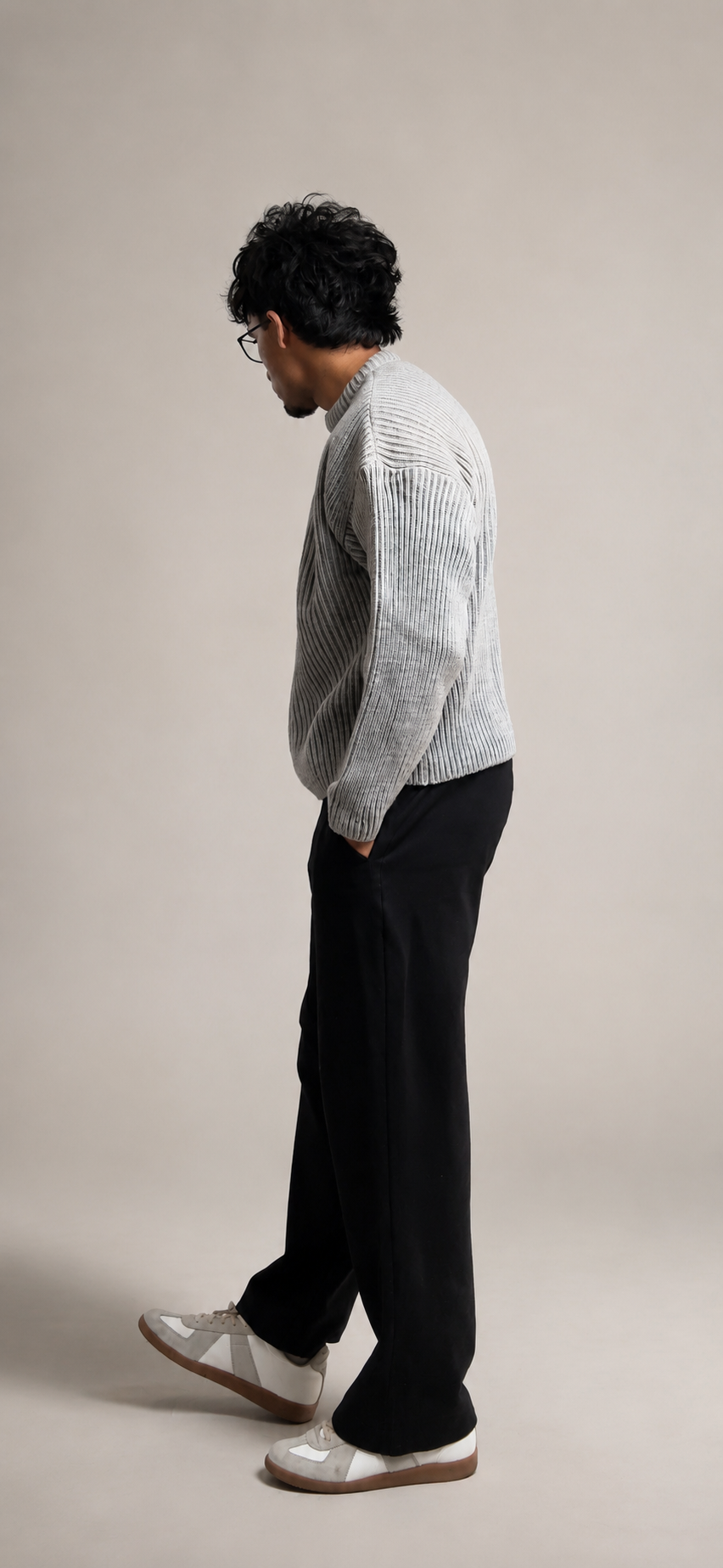 Dishen Patel wearing a grey knit jumper in a studio portrait